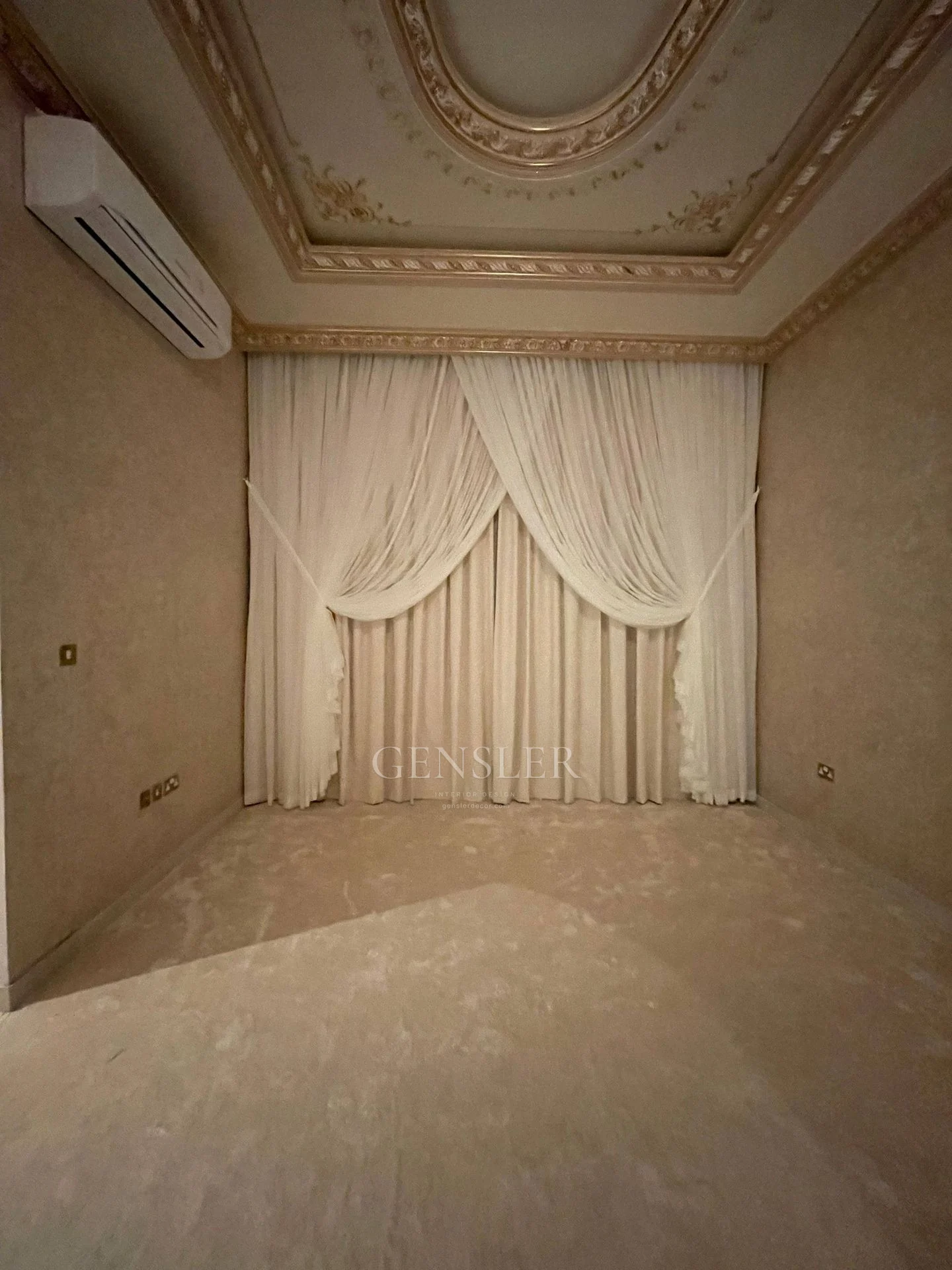 Cream gathered curtain panels below an ornamental ceiling.