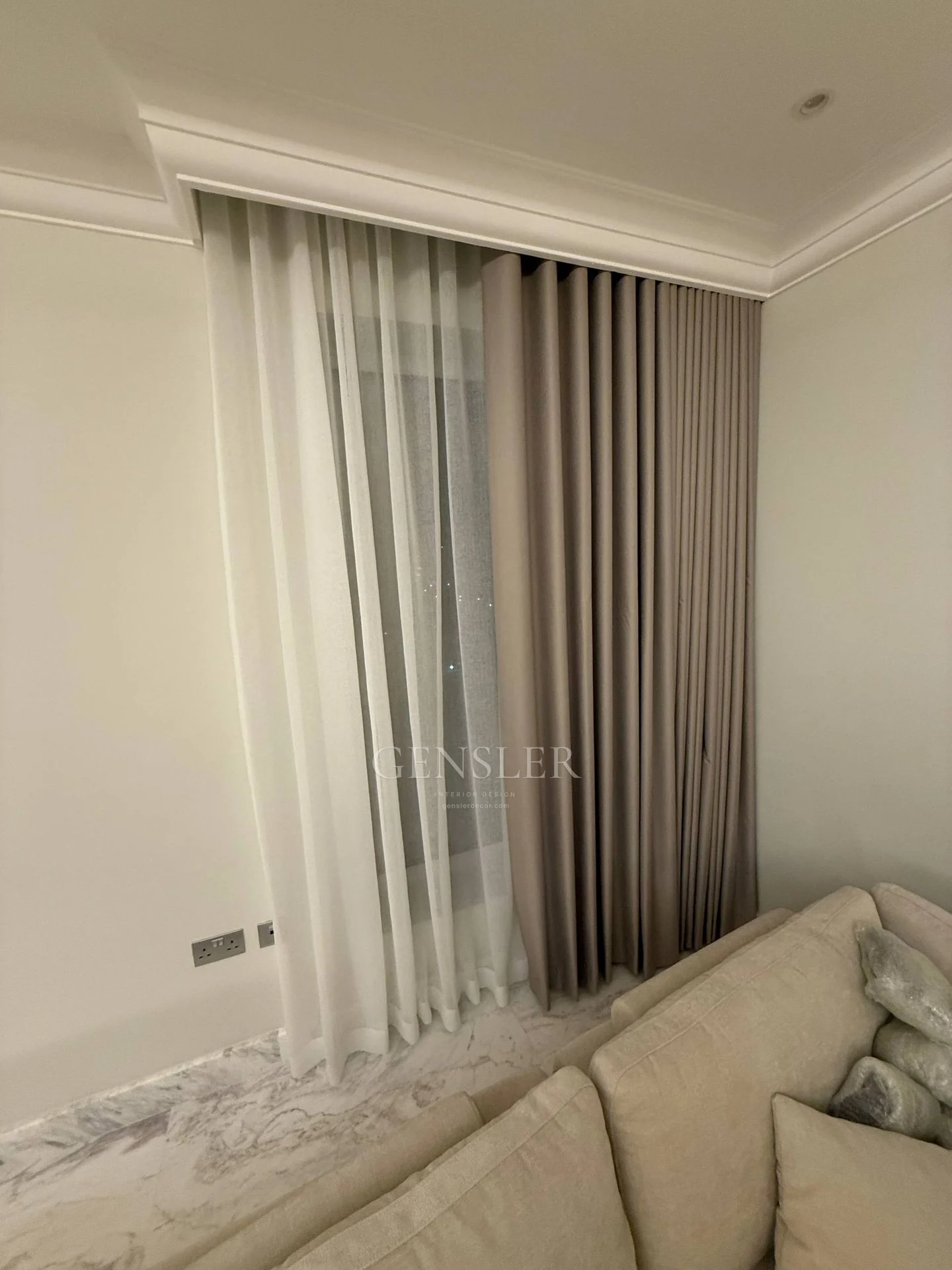 Layered grey and sheer curtains at a living-room window.