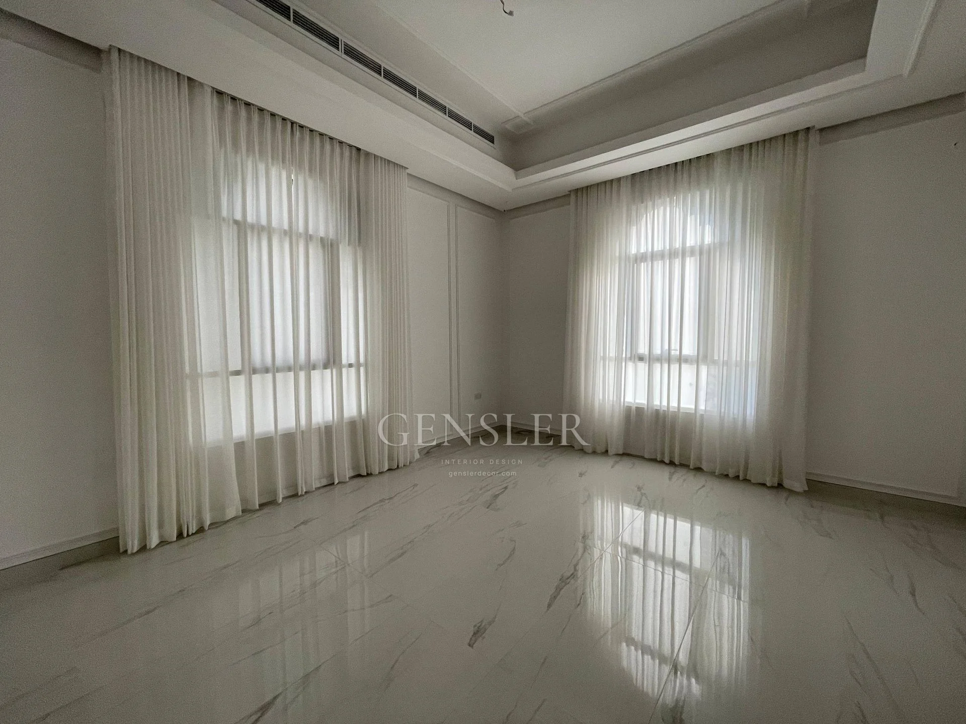 Corner view of two window walls covered with ivory sheers.