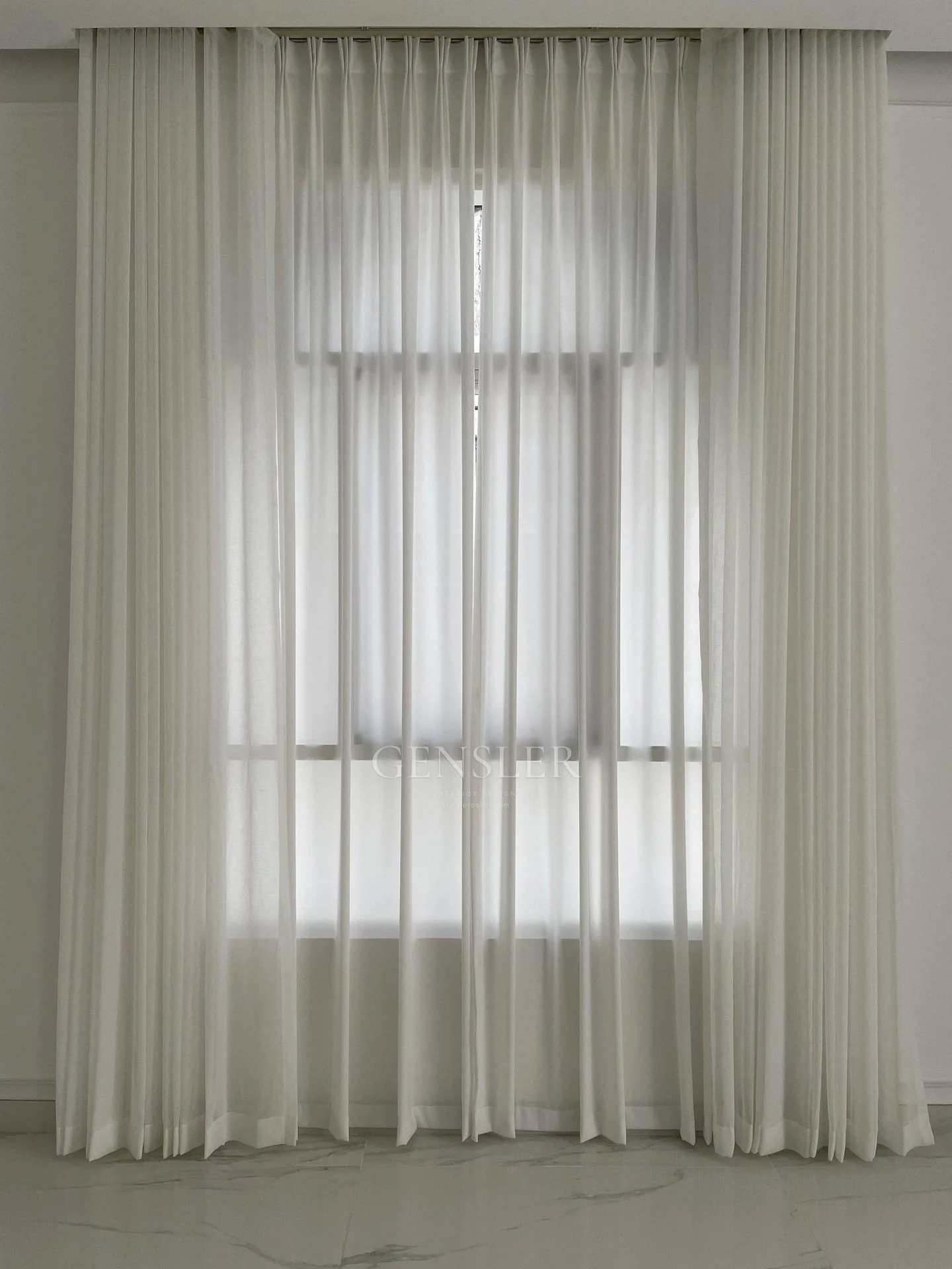 Close view of regular sheer folds and an arched window outline.