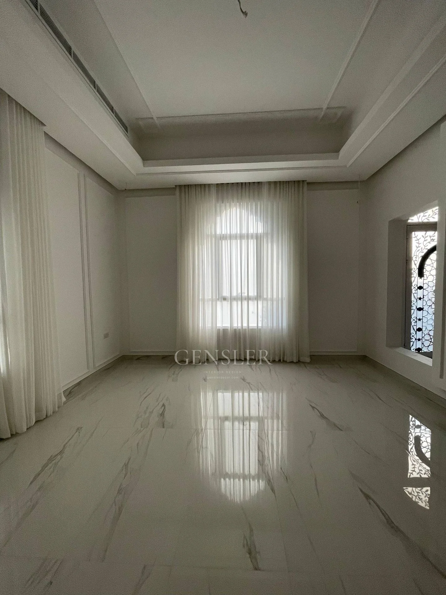 Long view of ivory sheers and an arched window reflected on pale flooring.