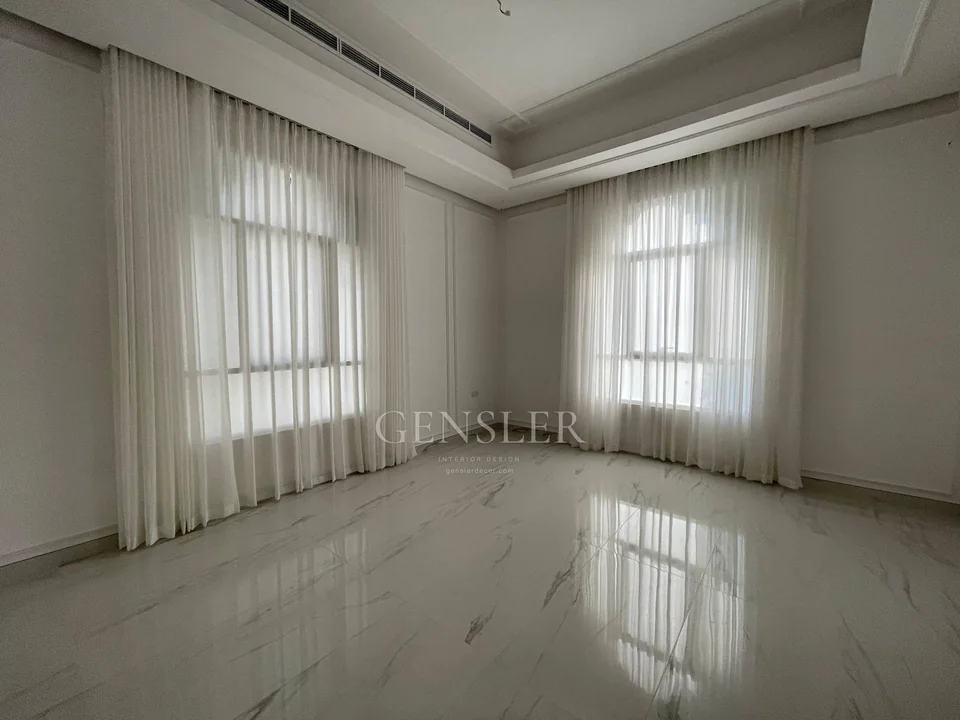 Corner view of two window walls covered with ivory sheers.