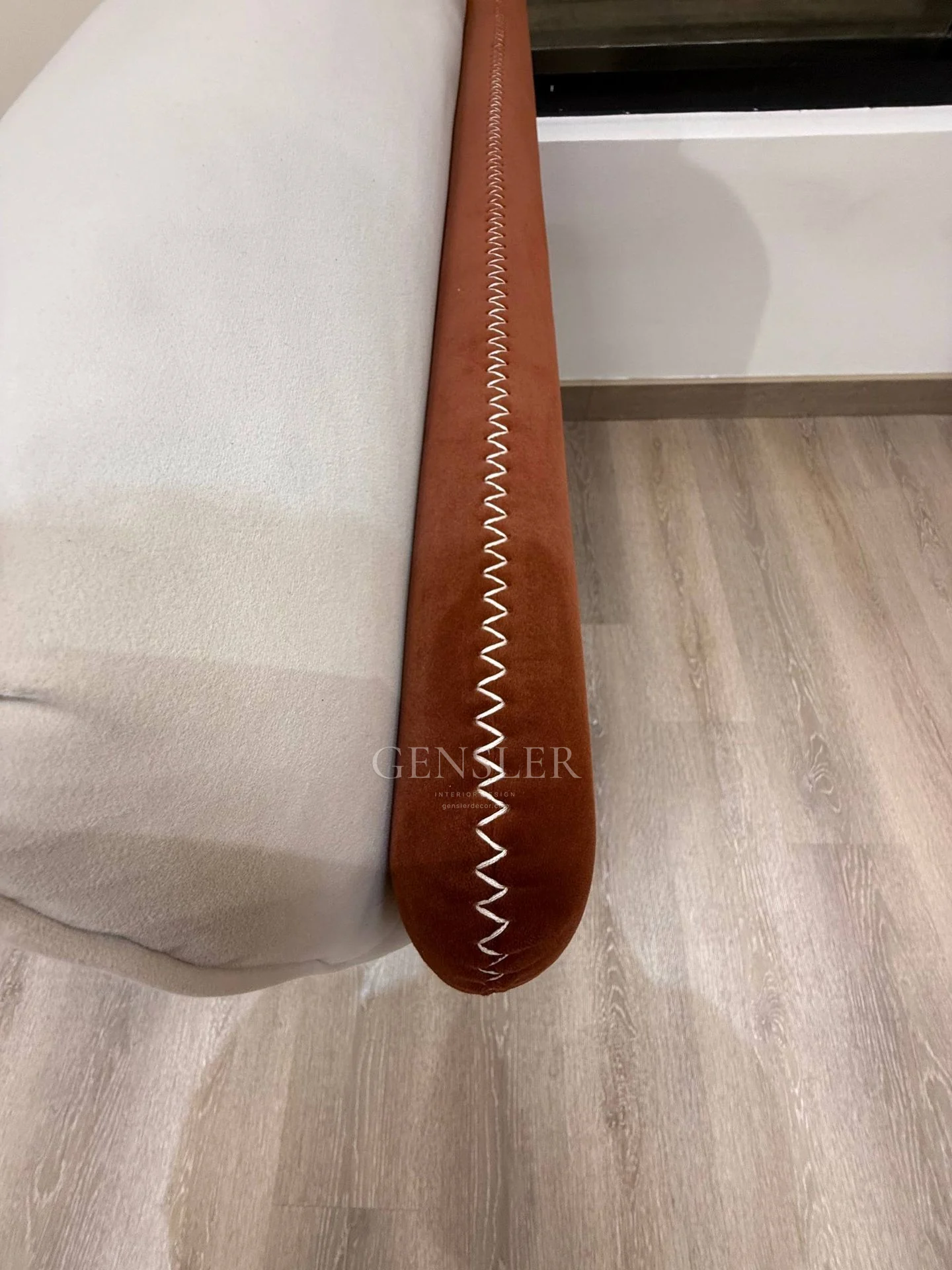 Close view of brown upholstery edging and contrasting stitching.