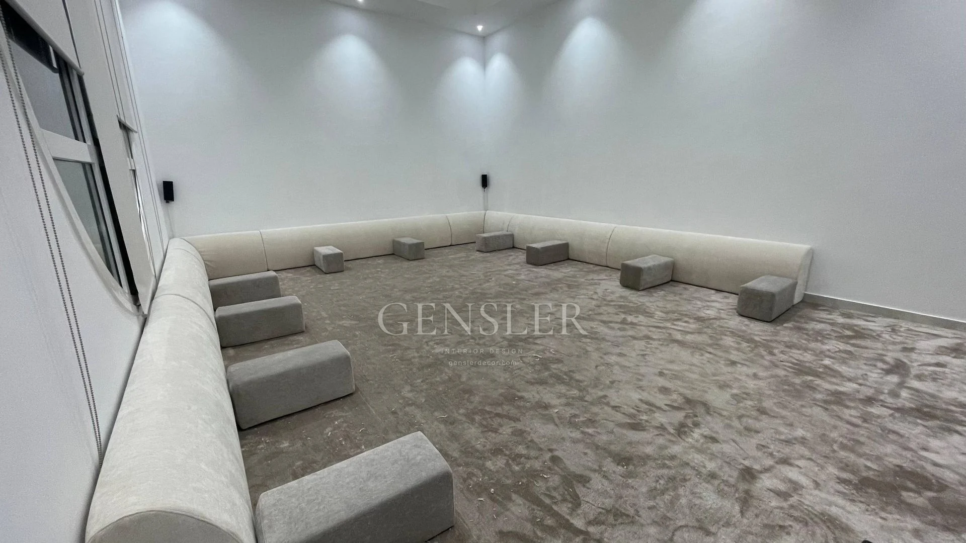 Low ivory perimeter majlis seating and a tonal grey carpet.