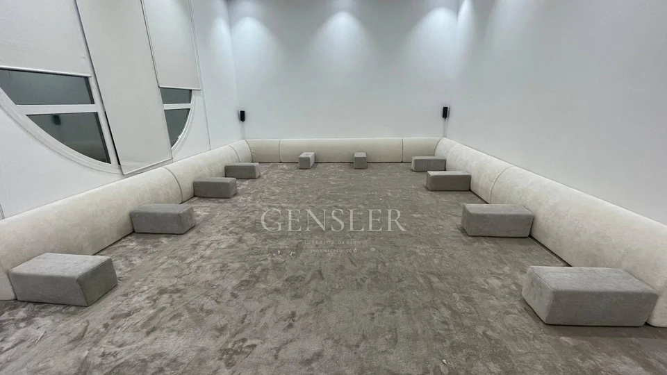 Wide view of the minimalist floor majlis and small grey supports.