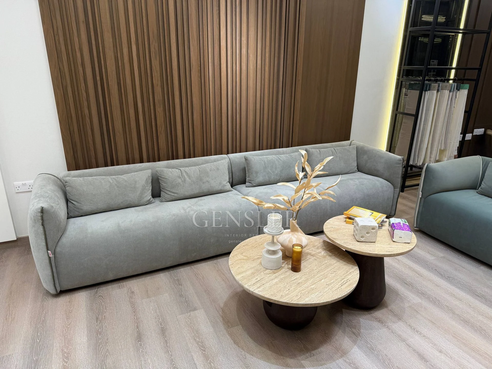 Long grey sofa with round nesting tables and a vertical slatted wall.