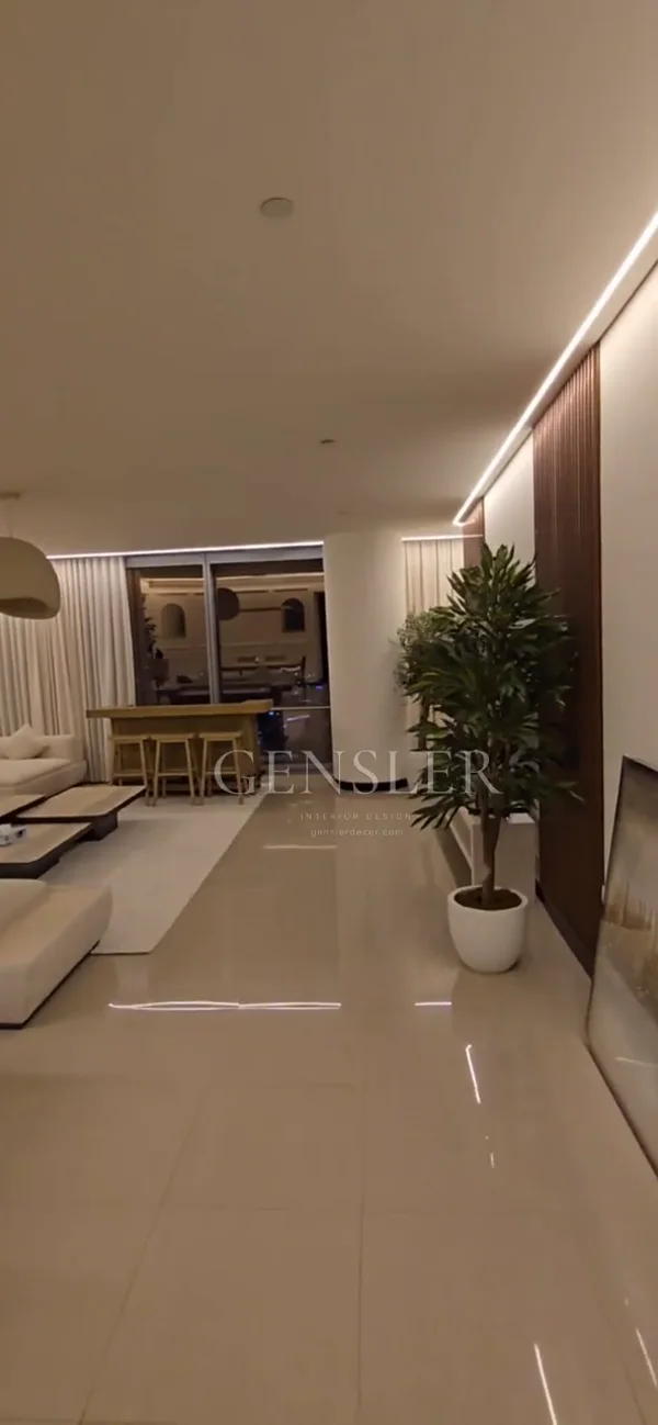 A room tour connecting the seating, slatted wall details and dining area beneath continuous ceiling light.