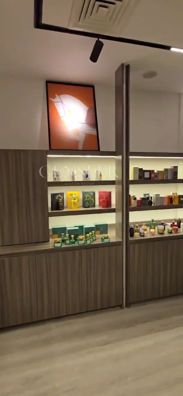 A walk from the storefront into a warm interior of illuminated display shelves and wood-tone cabinetry.